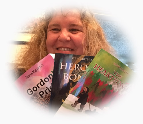 Julia holding her first three books in the NewEarth series.